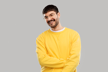 Image showing smiling young man in glasses and yellow sweatshirt