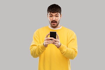 Image showing surprised young man with smartphone