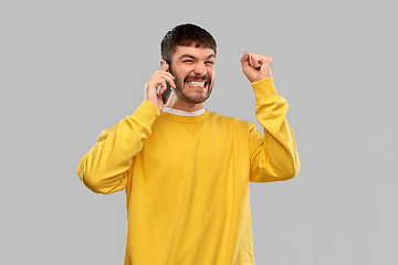 Image showing happy smiling young man calling on smartphone