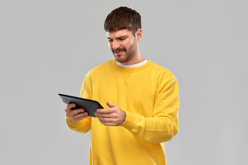 Image showing displeased young man with tablet pc computer