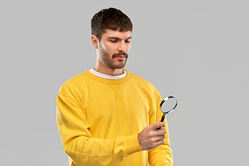 Image showing man in yellow sweatshirt with magnifier