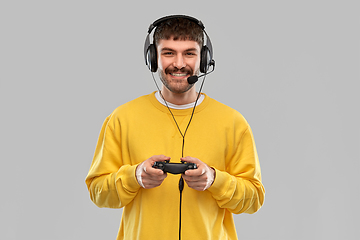 Image showing man with headset and gamepad playing video game