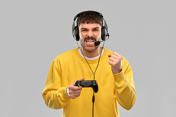 Image showing man with headset and gamepad playing video game