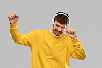 Image showing happy smiling young man in headphones dancing