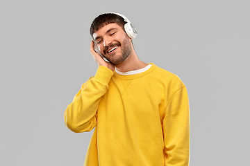 Image showing happy young man in headphones listening to music