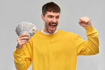 Image showing happy young man with money celebrating success