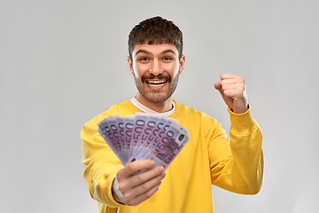 Image showing happy young man with money celebrating success