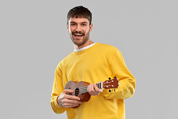 Image showing smiling young man playing ukulele guitar