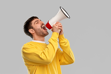 Image showing man in yellow sweatshirt shouting to megaphone