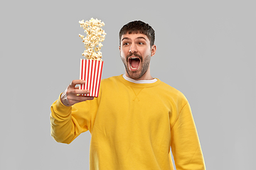 Image showing man in yellow sweatshirt playing with popcorn