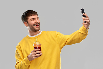 Image showing happy man with smartphone and juice taking selfie