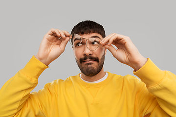 Image showing goofy young man in glasses and yellow sweatshirt