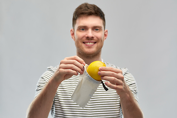 Image showing smiling man with lemon in reusable canvas bag