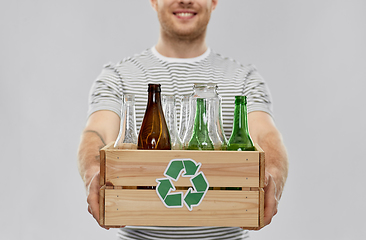 Image showing smiling young man sorting glass waste