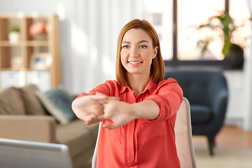 Image showing happy woman stretching arms at home office