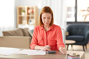 Image showing woman with calculator and papers working at home