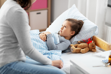 Image showing mother and sick daughter lying in bed at home