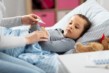 Image showing mother measuring temperature of sick daughter