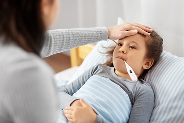 Image showing mother and sick daughter measuring temperature