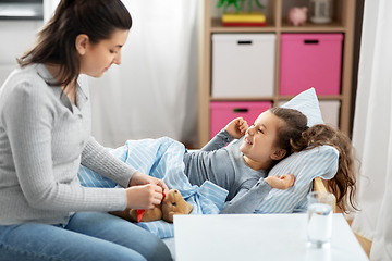 Image showing mother and happy little daughter in bed at home