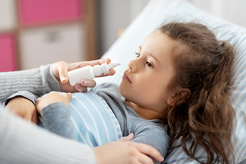 Image showing mother with nasal spray treats sick daughter