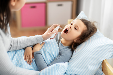 Image showing mother with oral spray treats sick little daughter