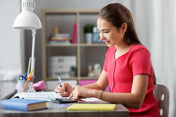 Image showing student girl counting on calculator at home