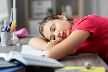 Image showing tired student girl sleeping on table at home