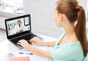 Image showing woman having video call with male doctor on laptop