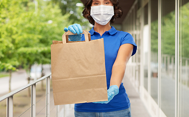 Image showing delivery woman in face mask with paper bag