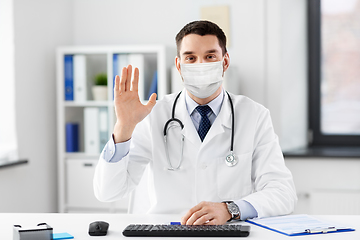 Image showing happy male doctor waving hand at hospital