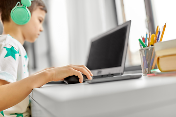 Image showing boy in headphones playing video game on laptop