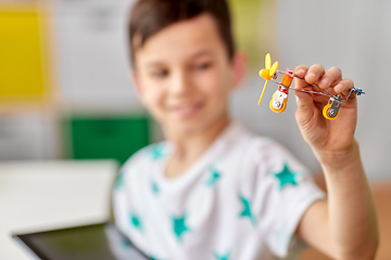 Image showing happy little boy playing with airplane toy at home