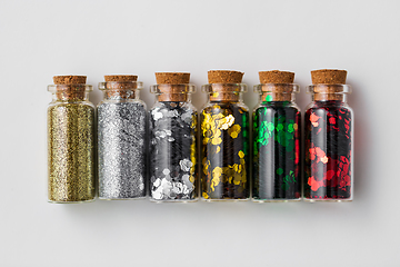 Image showing set of glitters in bottles over white background