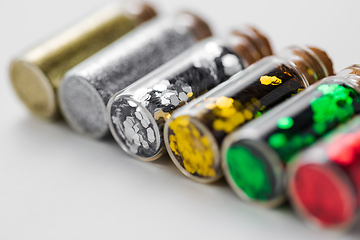 Image showing set of glitters in bottles over white background