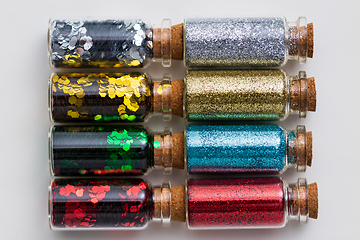 Image showing set of glitters in bottles over white background