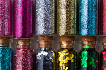 Image showing set of different glitters in small glass bottles