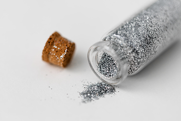 Image showing silver glitters poured from small glass bottle