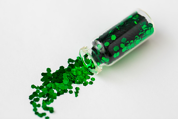 Image showing green glitters poured from small glass bottle