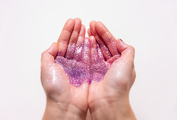 Image showing hands holding glitters on white background