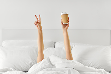 Image showing woman with coffee lying in bed showing peace