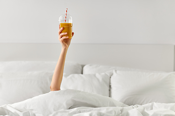 Image showing hand of woman lying in bed with cup of juice