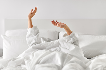 Image showing hands of woman lying in bed and stretching