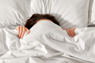 Image showing woman lying in bed under white blanket or duvet