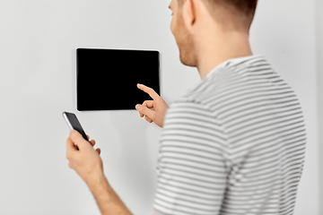 Image showing man with smartphone and tablet pc at smart home