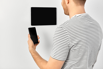 Image showing man with smartphone and tablet pc at smart home