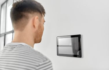 Image showing man looking at tablet computer at smart home