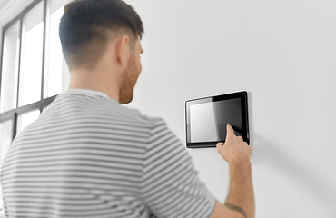 Image showing man looking at tablet computer at smart home