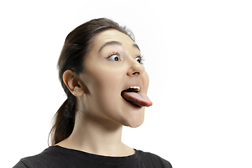 Image showing Smiling girl opening her mouth and showing the long big giant tongue isolated on white background, crazy and attracted