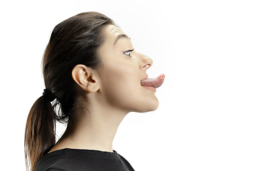 Image showing Smiling girl opening her mouth and showing the long big giant tongue isolated on white background, crazy and attracted